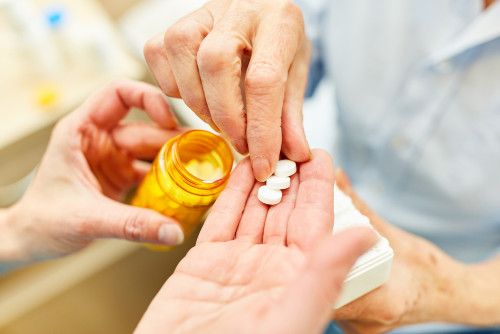 pflegedienste Pflegedienste, Symbol Foto, mit Händen die Tabletten verteilen